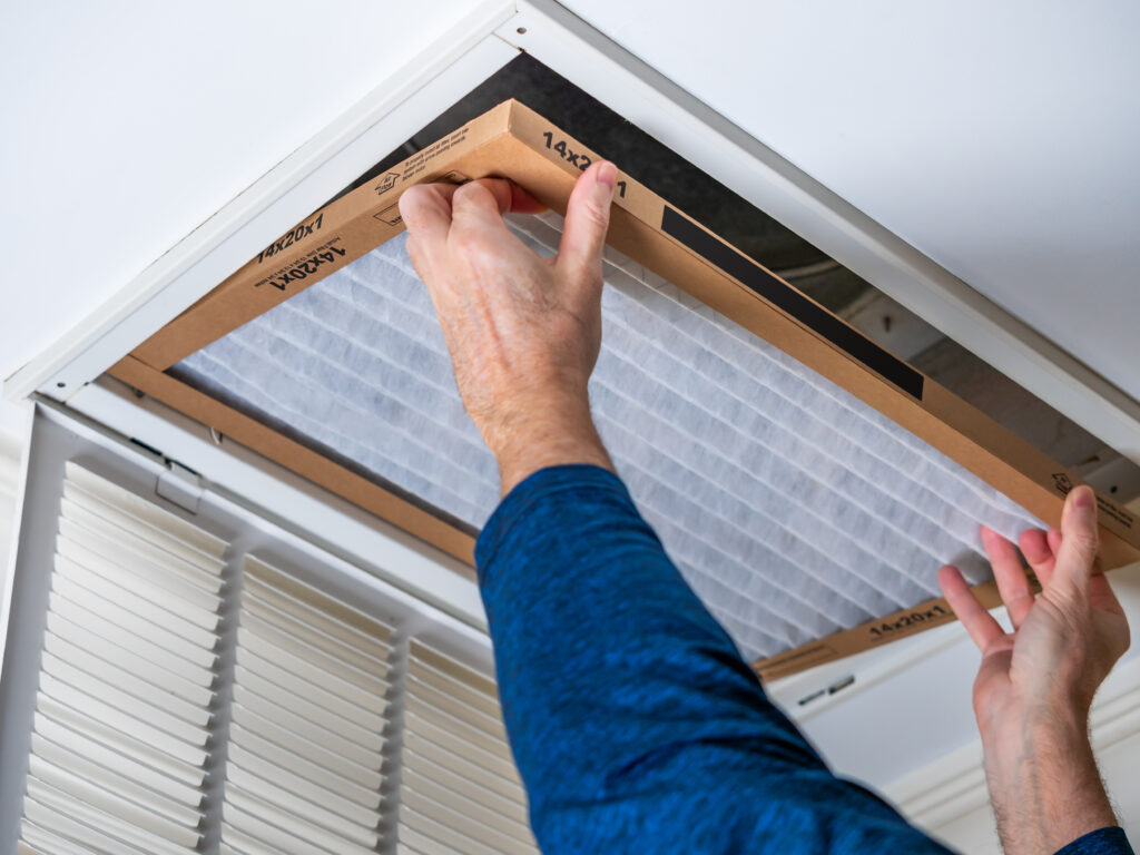 HVAC technician replacing a home air filter in Arcadia