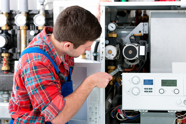 Heating technician repairing boiler controls in Arcadia
