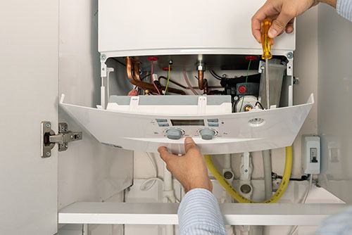 Heating technician repairing a residential boiler in Arcadia