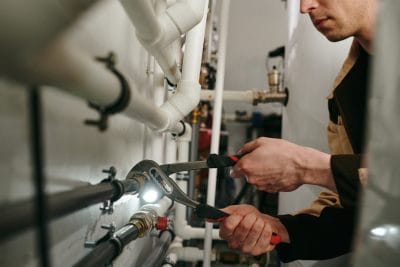 Technician inspecting commercial plumbing pipes in Arcadia