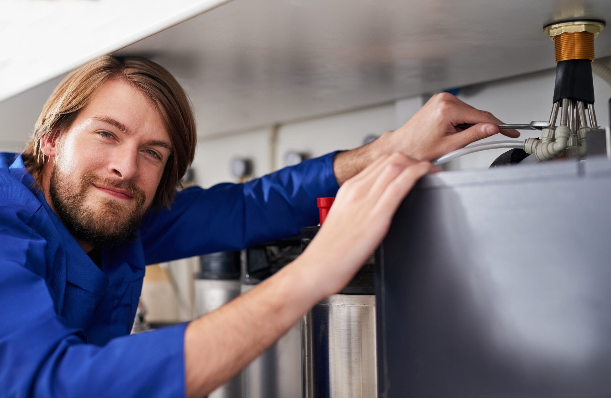 Technician servicing a residential water heater tank in Arcadia